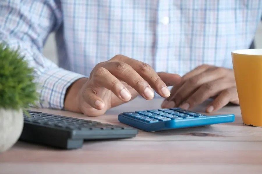 Hands using a calculator during a financial review