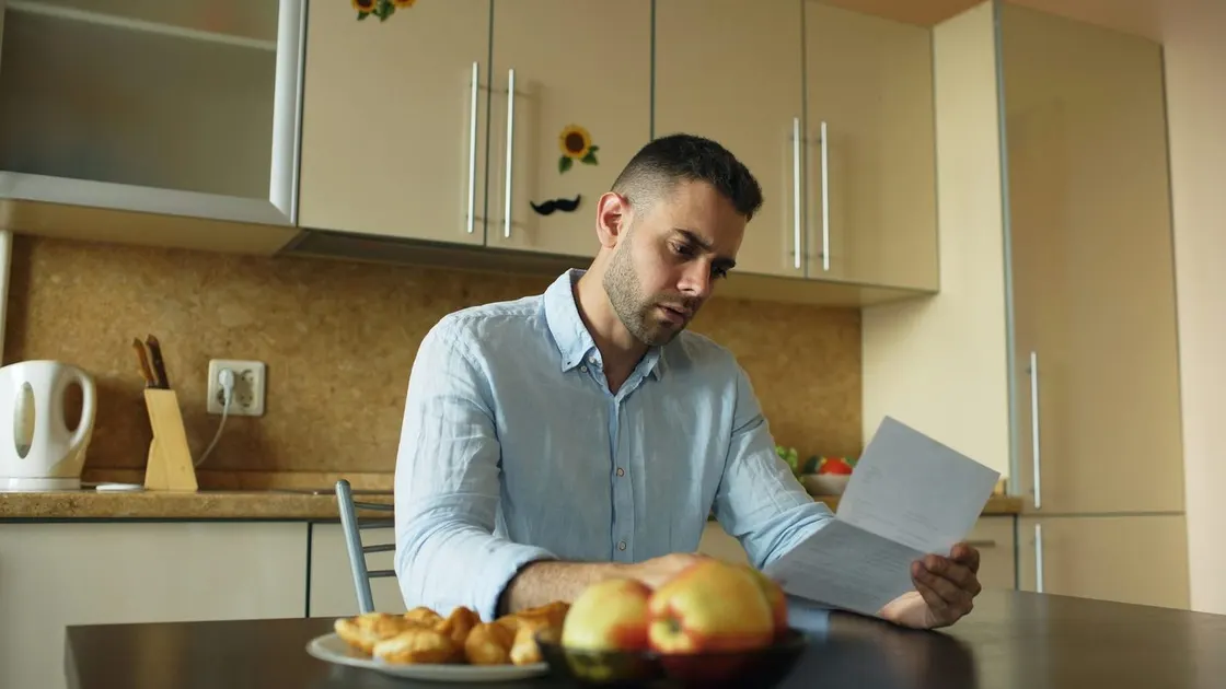 Person reviewing household bills at a table
